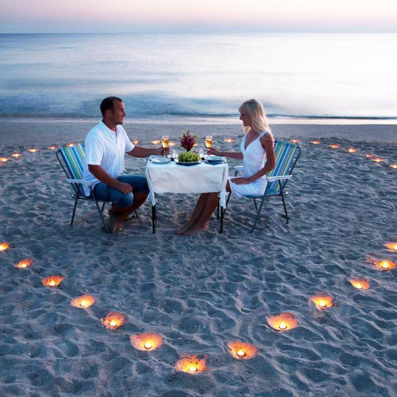 Pasangan kekasih sedang melakukan dinner romantis di pinggir pantai
